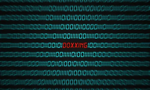 Computer screen with binary code and the word DOXXING in red