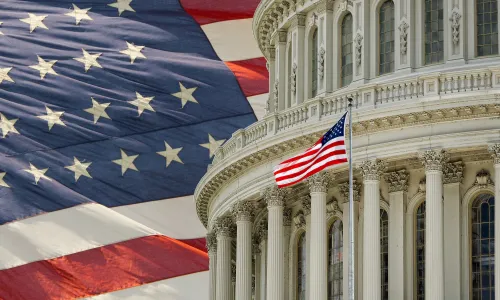 Capitol Building dome with an American flag in the background in Washington DC