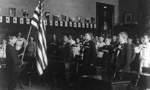 Group of children reciting pledge of allegiance to the flag in 1899