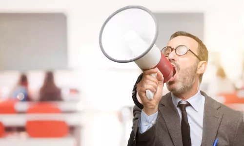 Teacher shouting holding a megaphone in a classroom