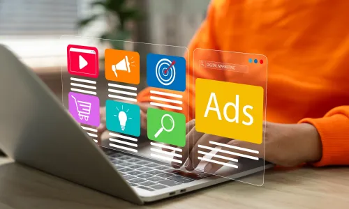 Person at a computer with a digital display showing advertisements