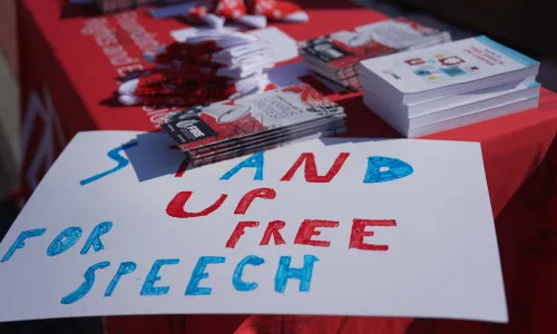 FIRE table at University of Illinois Urbana Champaign with a sign on the corner that reads "stand up for free speech". Photography by Sylwia Sawicka.