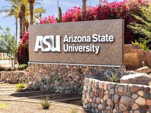 Arizona State University entrance sign in Tempe surrounded by sand, stone, and cactus