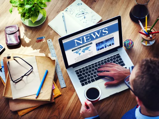 Person writing on a computer at a desk