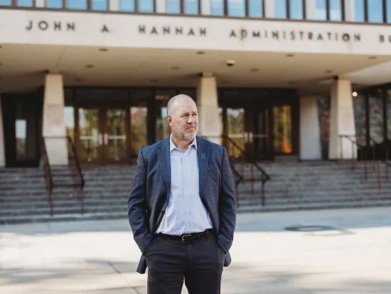 FIRE plaintiff Michael Balow standing in front of the John Hannah Administration Building at Michigan State University