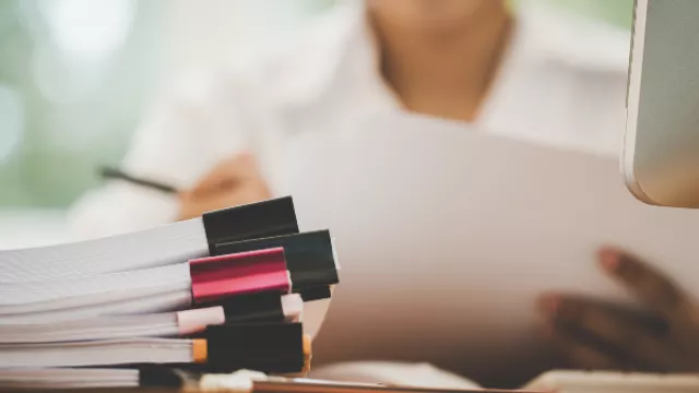 administrator reads papers at desk