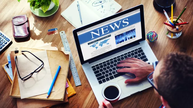 Person writing on a computer at a desk