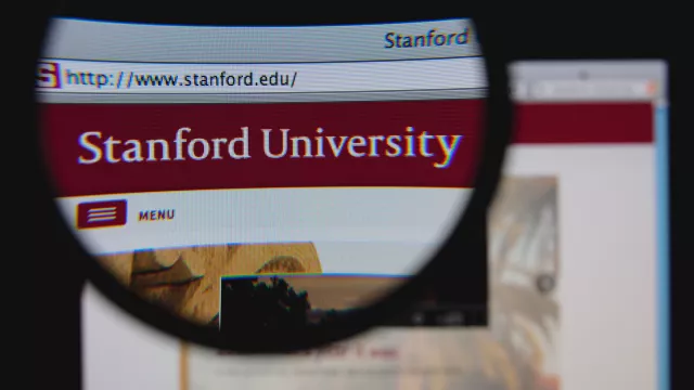 Photo of Stanford University homepage on a monitor screen through a magnifying glass 