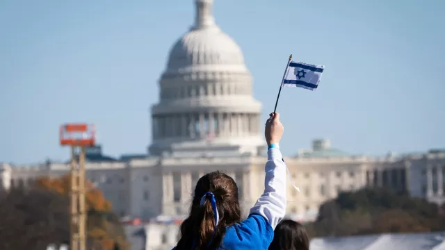 A child waves the flag of Israel at a rally during the March for Israel in Washington on the National Mall 