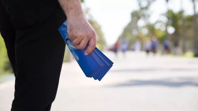 Man Distributing Evangelistic Flyers in a Park