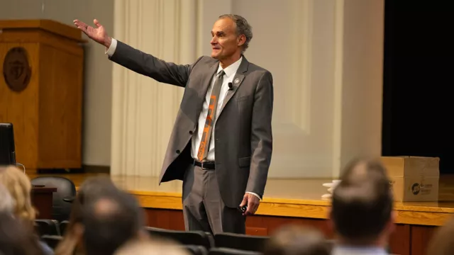 UW-La Crosse professor Joe Gow gestures to an audience in an auditorium on campus