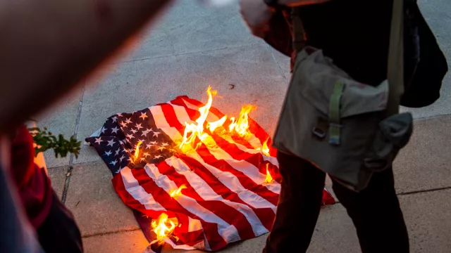 Protesters burning the American flag.