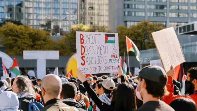 Protesters march in the city holding signs advocating for Boycott Divestment and Sanctions on October 28, 2023