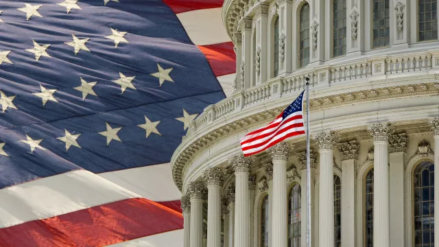 Capitol Building dome with an American flag in the background in Washington DC