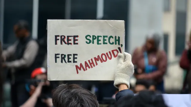 Protester holding a sign that reads Free Speech Free Mahmoud March 12 2025