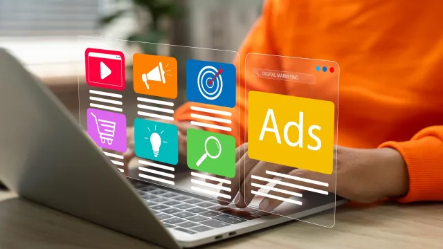 Person at a computer with a digital display showing advertisements