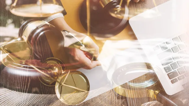 Contract papers with brass scale on desk in office justice and law concept picture with film grain effect.jpg