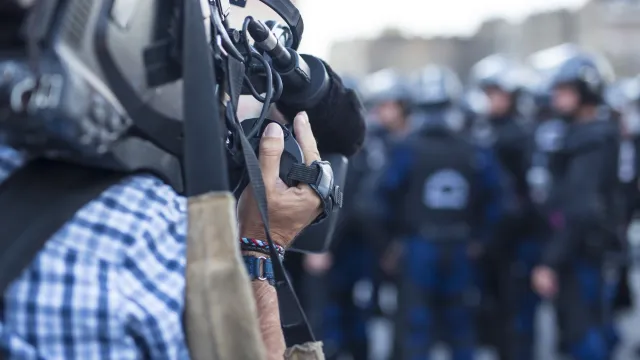 News cameraman films police on the streets