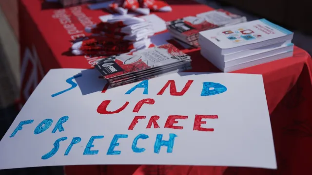 FIRE table at University of Illinois Urbana Champaign with a sign on the corner that reads "stand up for free speech". Photography by Sylwia Sawicka.