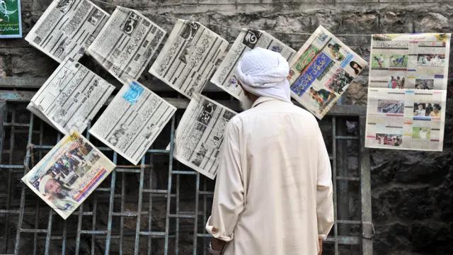 Man reads newspaper in Abbottabad, Pakistan.