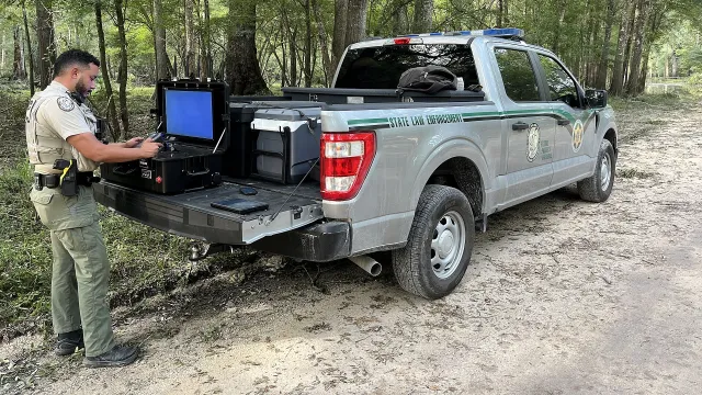 An FWC officer readies a drone at the back of his truck